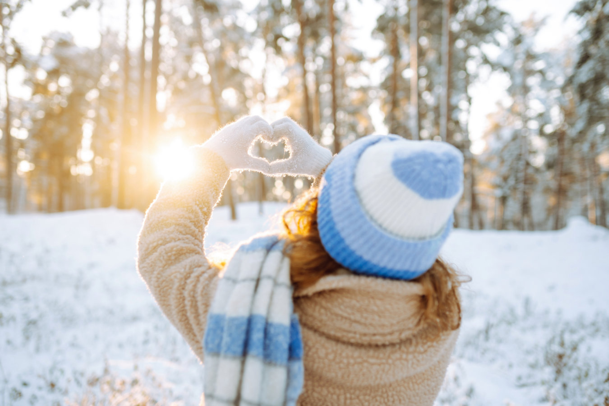 Счастливая путешественница делает сердце руками в солнечный замерзший зимний день на фоне снежного зимнего леса, Россия. Shutterstock
