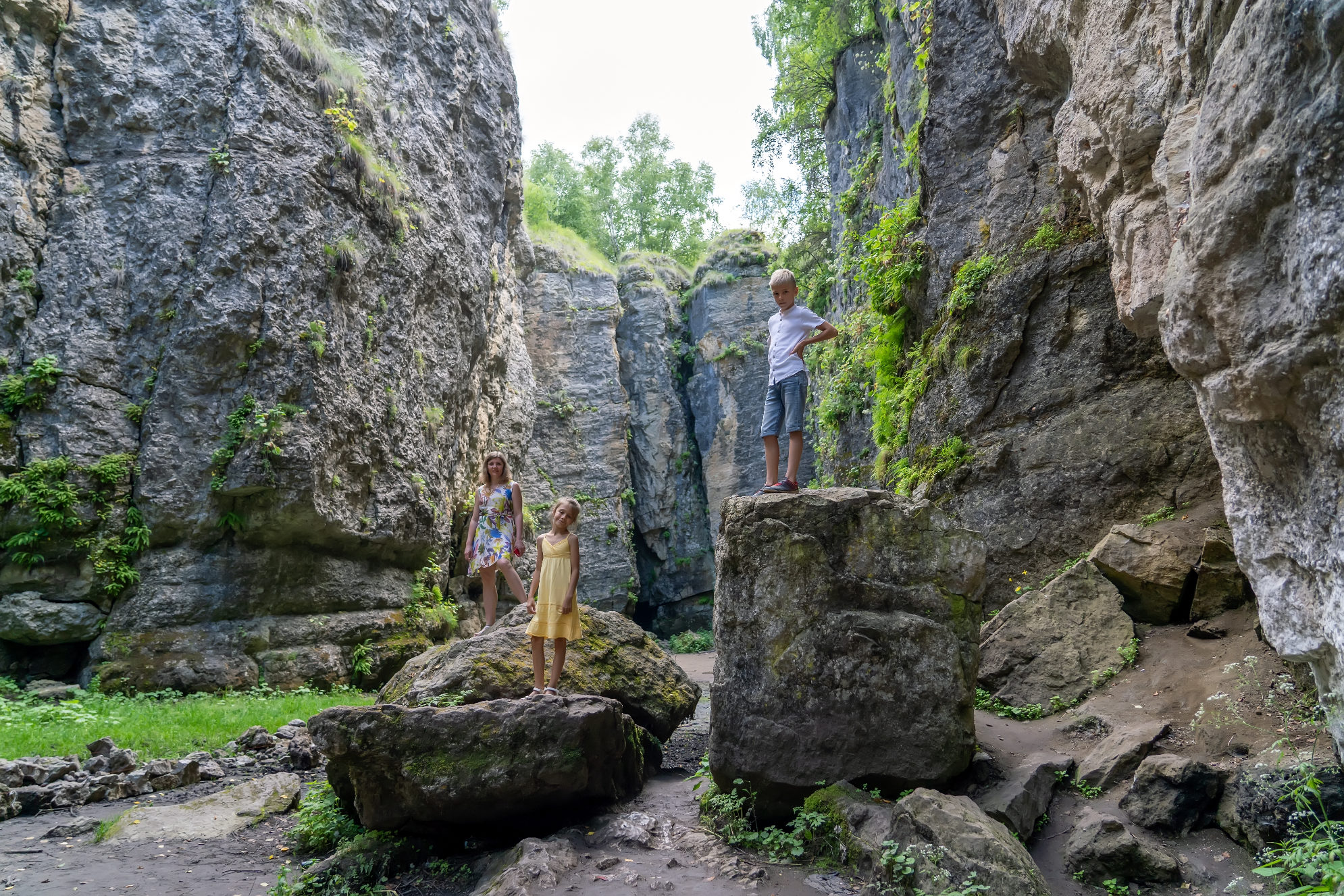 Мама с детьми гуляют в ущелье среди величественных отвесных скал. Источник: Shutterstock