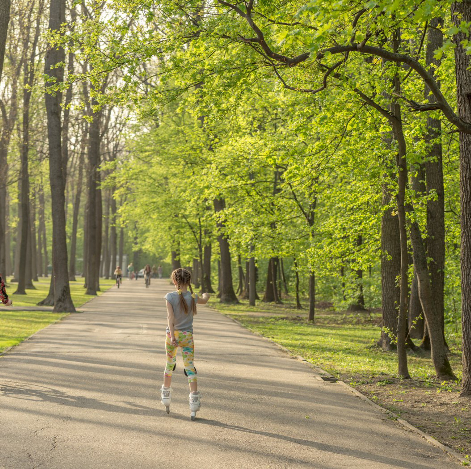 Девочка в парке на роликах.