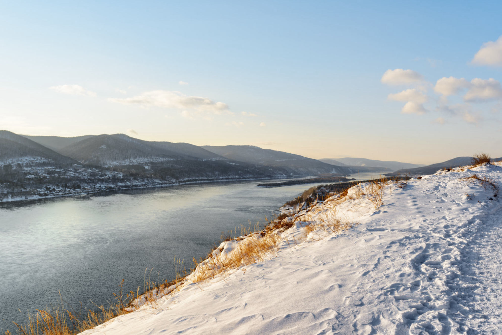 Вид сверху на реку Енисей среди живописных гор, покрытых снегом, Сибирь, Россия. Источник: Shutterstock