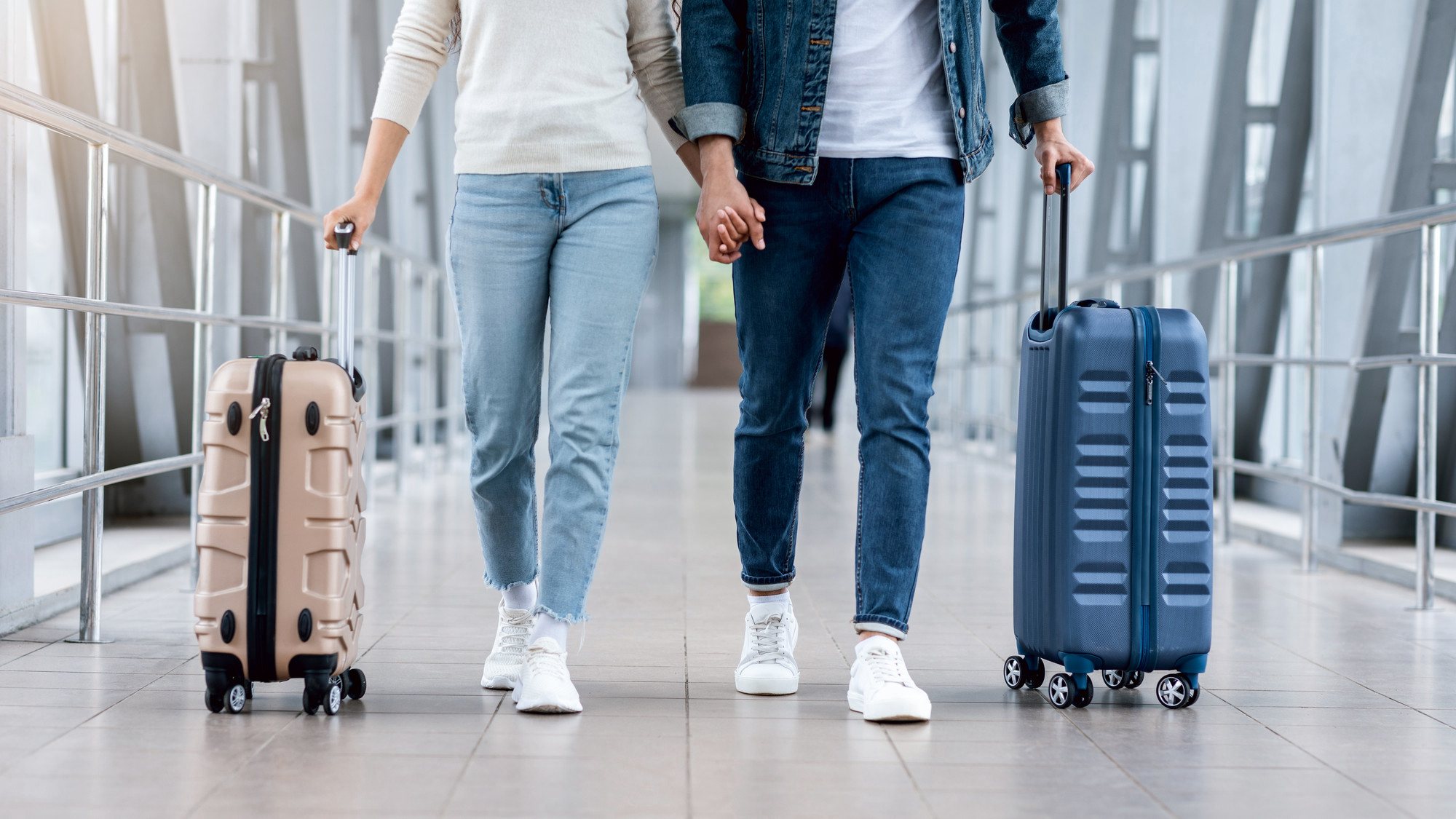 Пара идет по аэропорту с багажом. Источник: Shutterstock