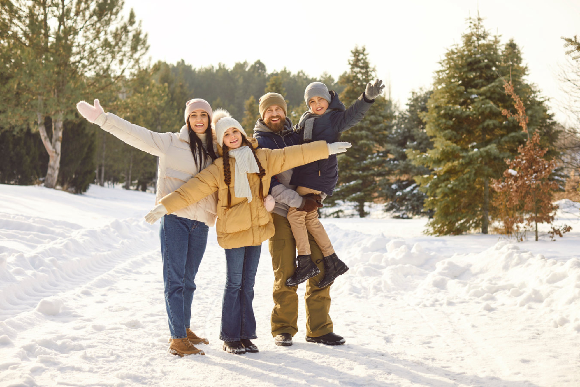 Счастливая семья на прогулке зимой в лесу, Россия. Shutterstock