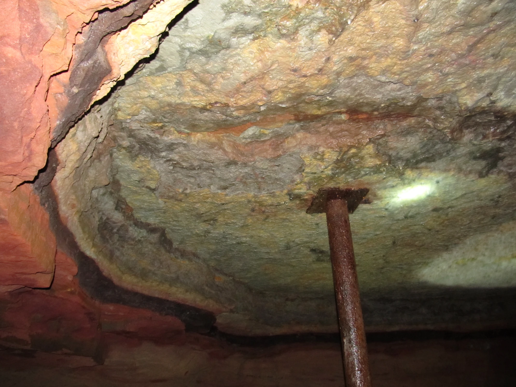 На стенах и сводах пещеры заметны разноцветные слои песчаника и известняка