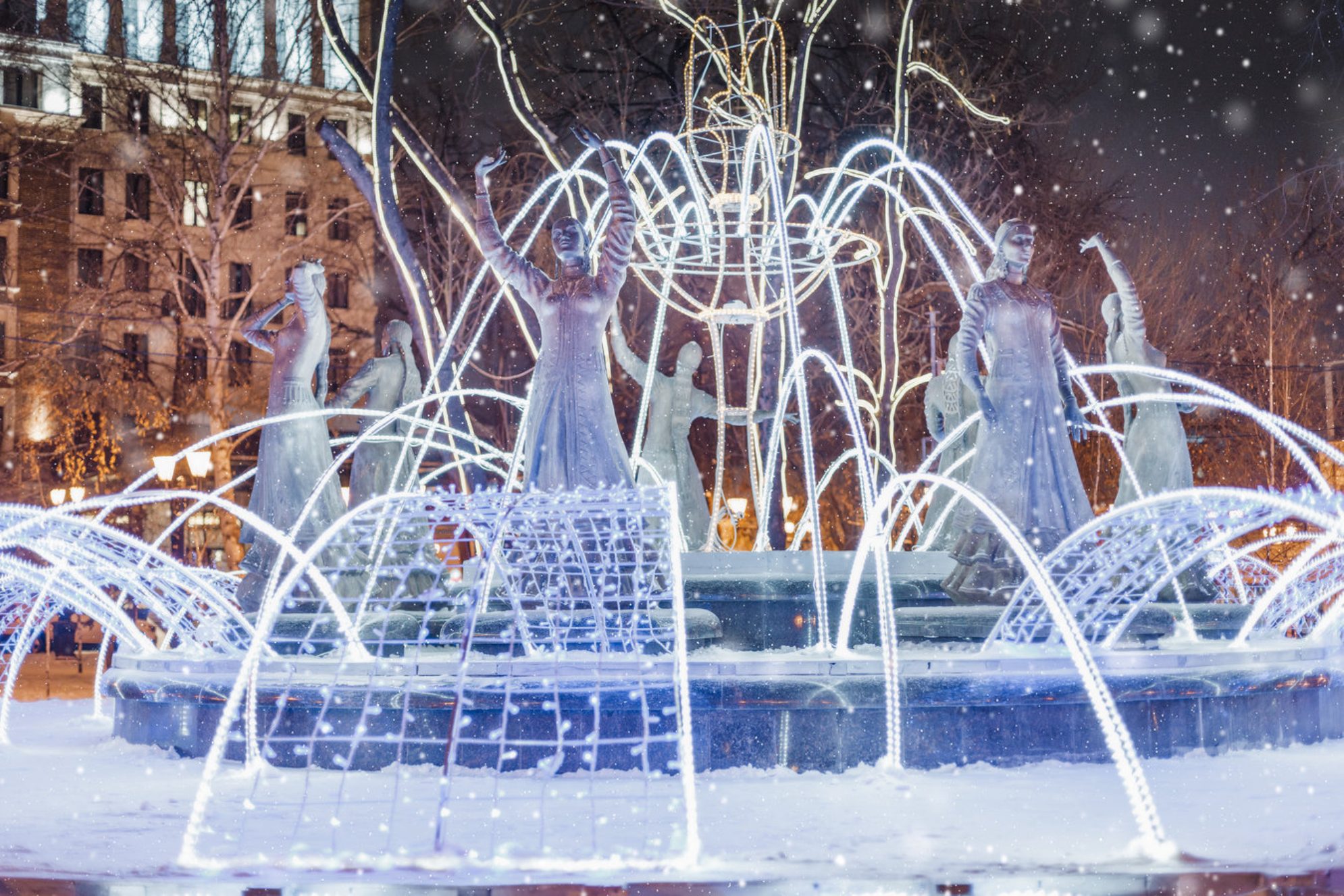 Украшенный гирляндами и мерцающими огнями фонтан в центре Уфы, Россия. Shutterstock