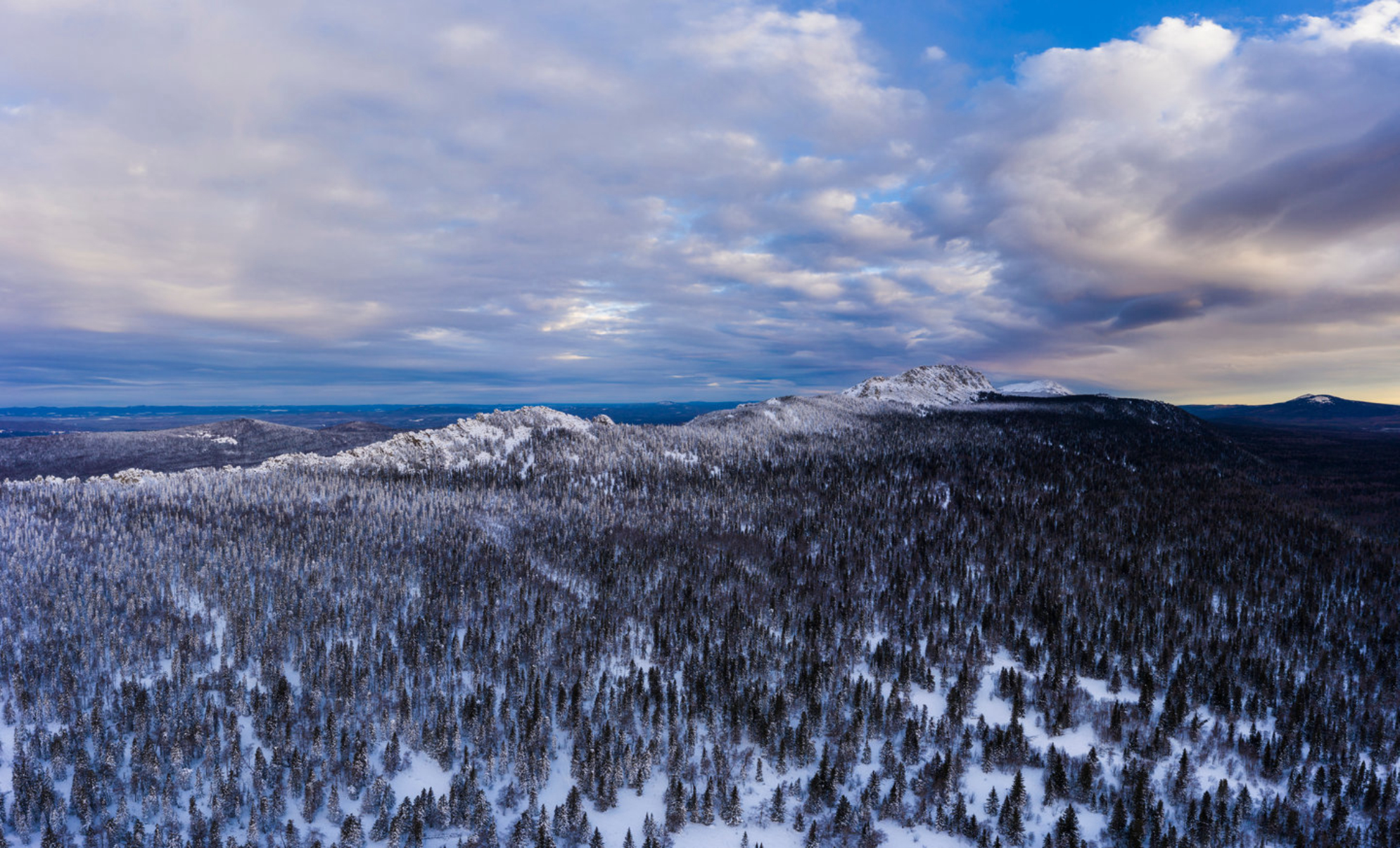 Горный хребет и хвойные деревья зимой. Вид с высоты птичьего полета. Национальный парк «Таганай», Южный Урал, Россия. Shutterstock