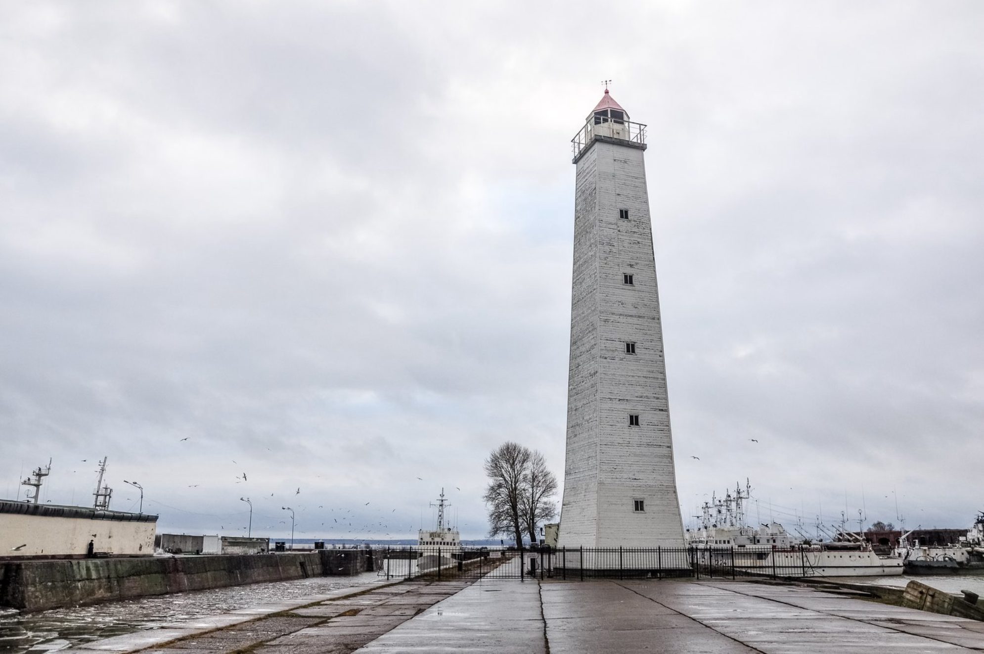 Белоснежный и стройный - деревянный маяк на пирсе сразу приковывает взгляд Shutterstock.