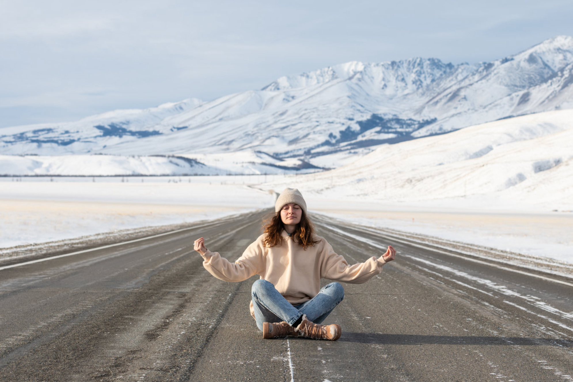 Молодая девушка медитирует на фоне гор зимой. Источник: Shutterstock