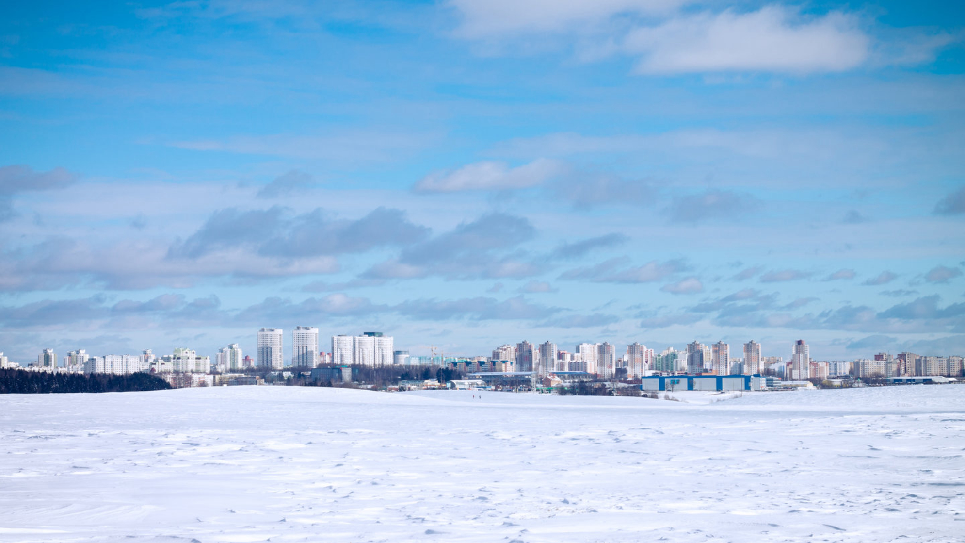 Пейзаж городских высотных зданий на фоне голубого неба и белого снега зимой. Республика Беларусь. shutterstock.com