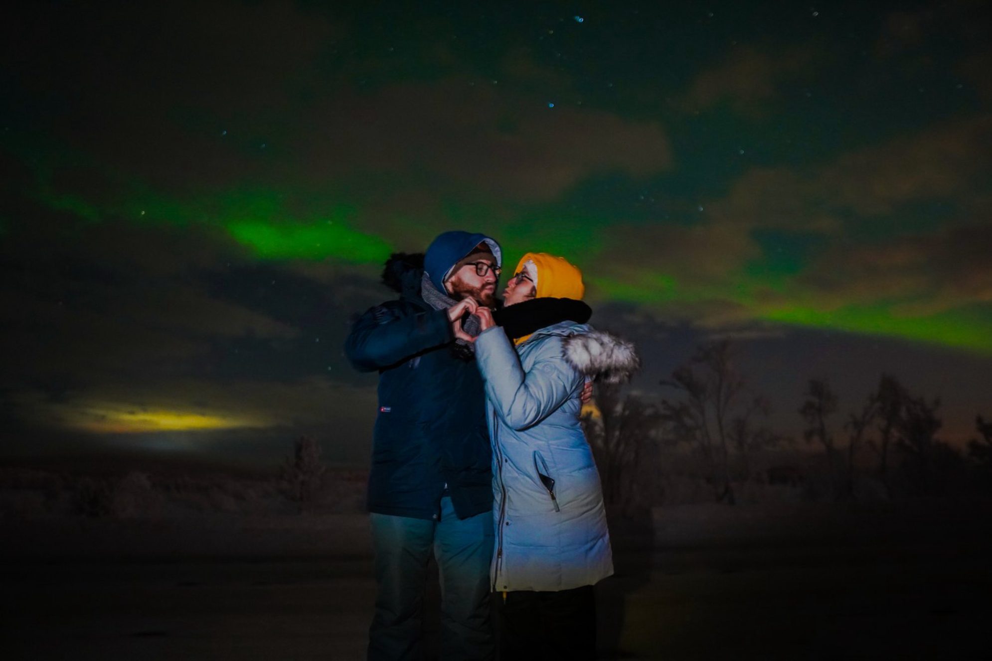 Влюбленная пара любуется сиянием в ночном северном небе