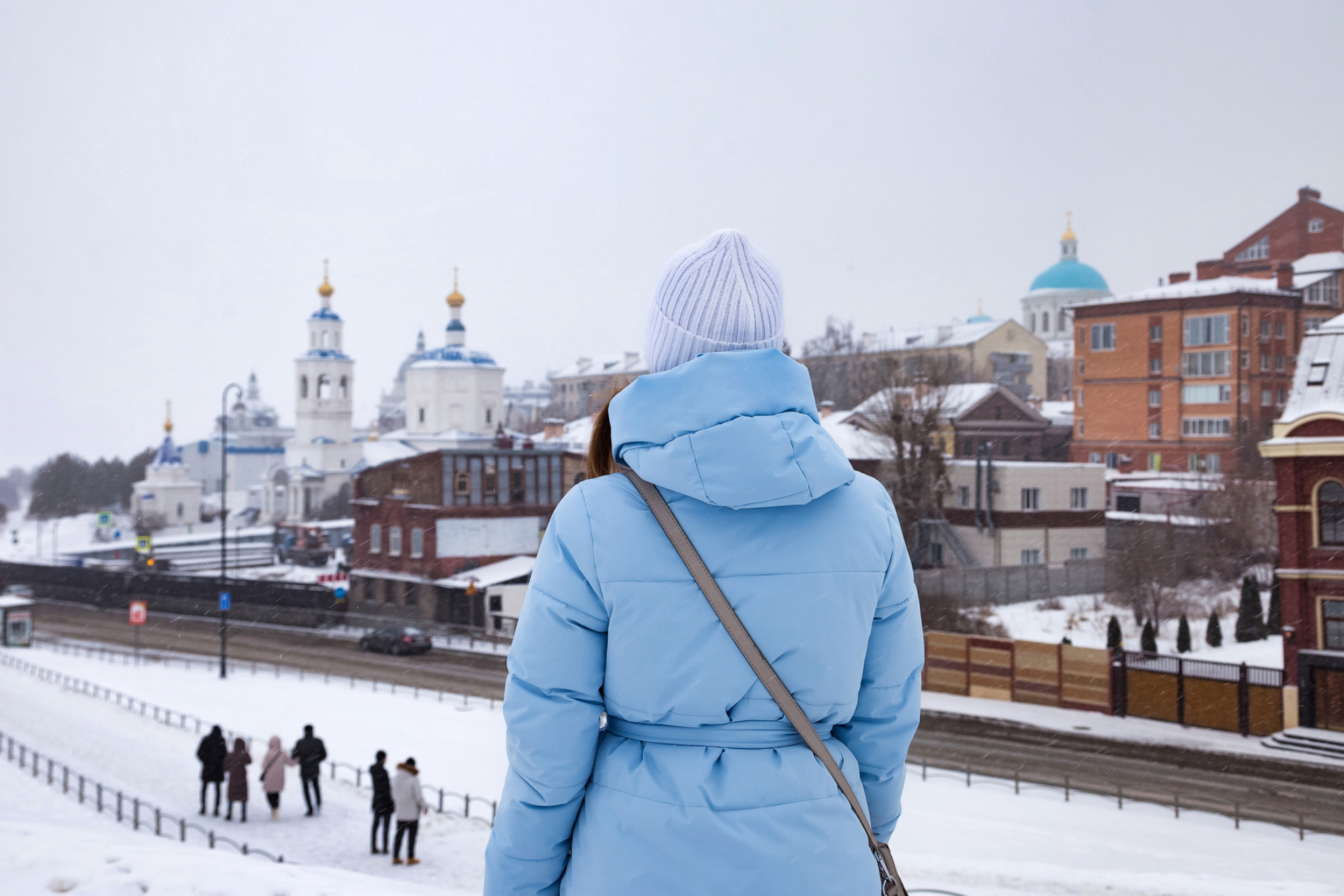 Девушка смотрит на покрытую снегом панораму Казани. Источник: Shutterstock