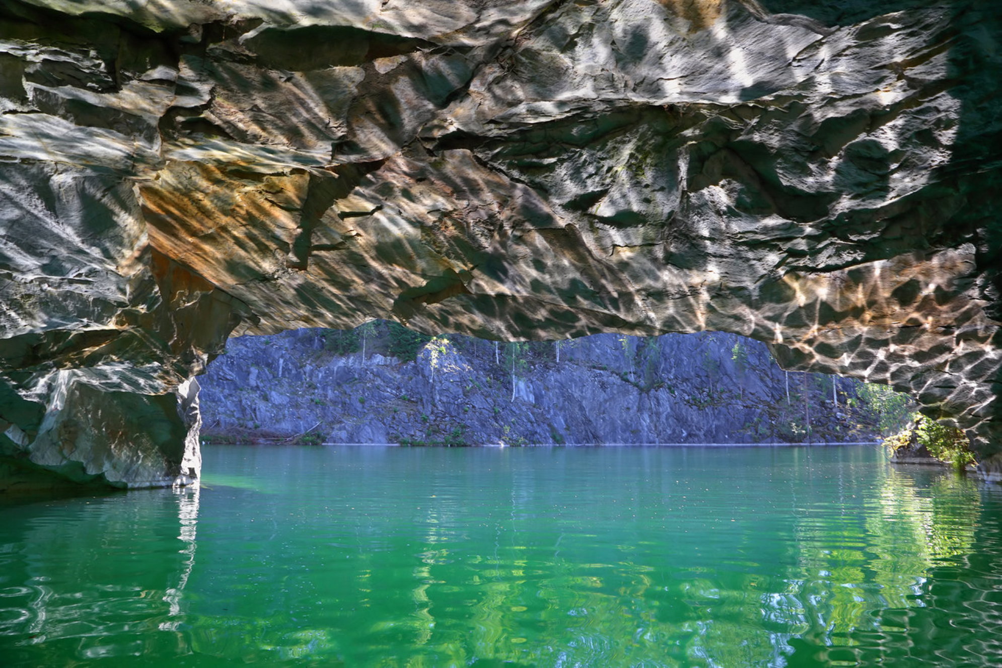 Блики солнца от воды на стенах пещеры в мраморном карьере в Рускеале, Карелия, Россия Shutterstock