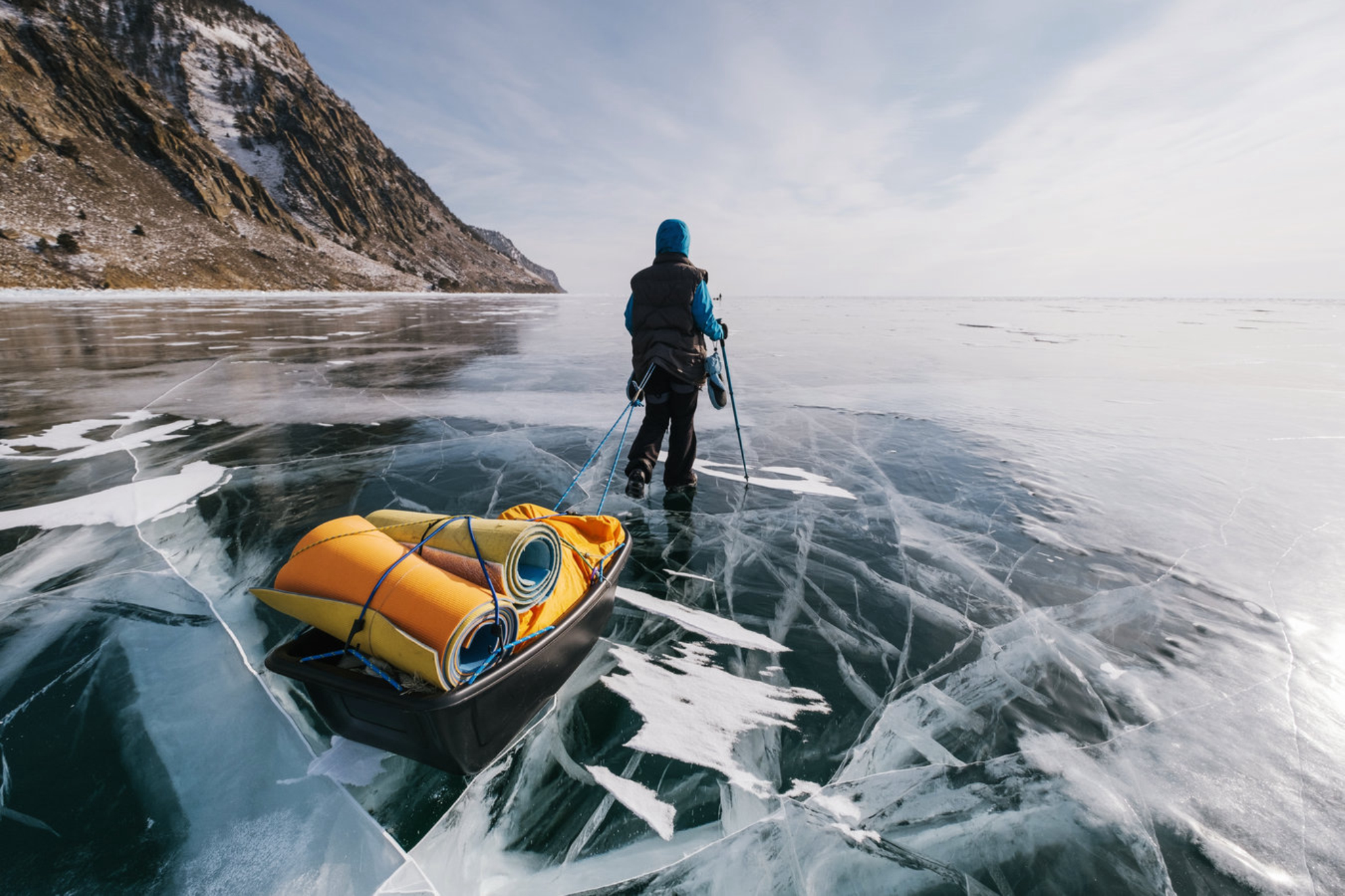 Туристы идут пешком с санями, волочащимися по льду озера Байкал. Зимний треккинг Shutterstock
