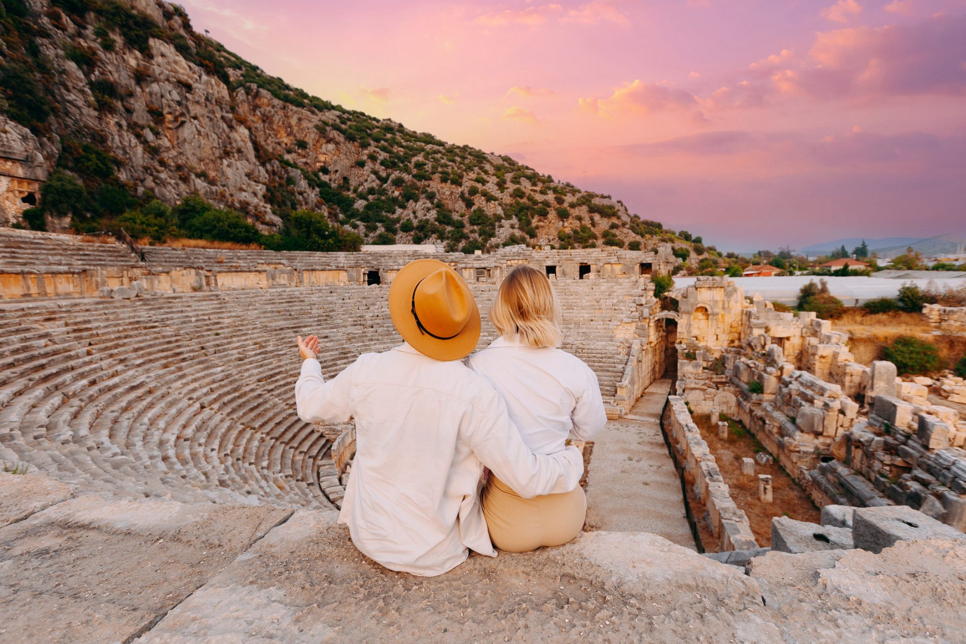 Пара туристов на фоне амфитеатра и ликийской скальной гробницы в древнем городе Демре, регион Анталья, Турция. Источник: Shutterstock