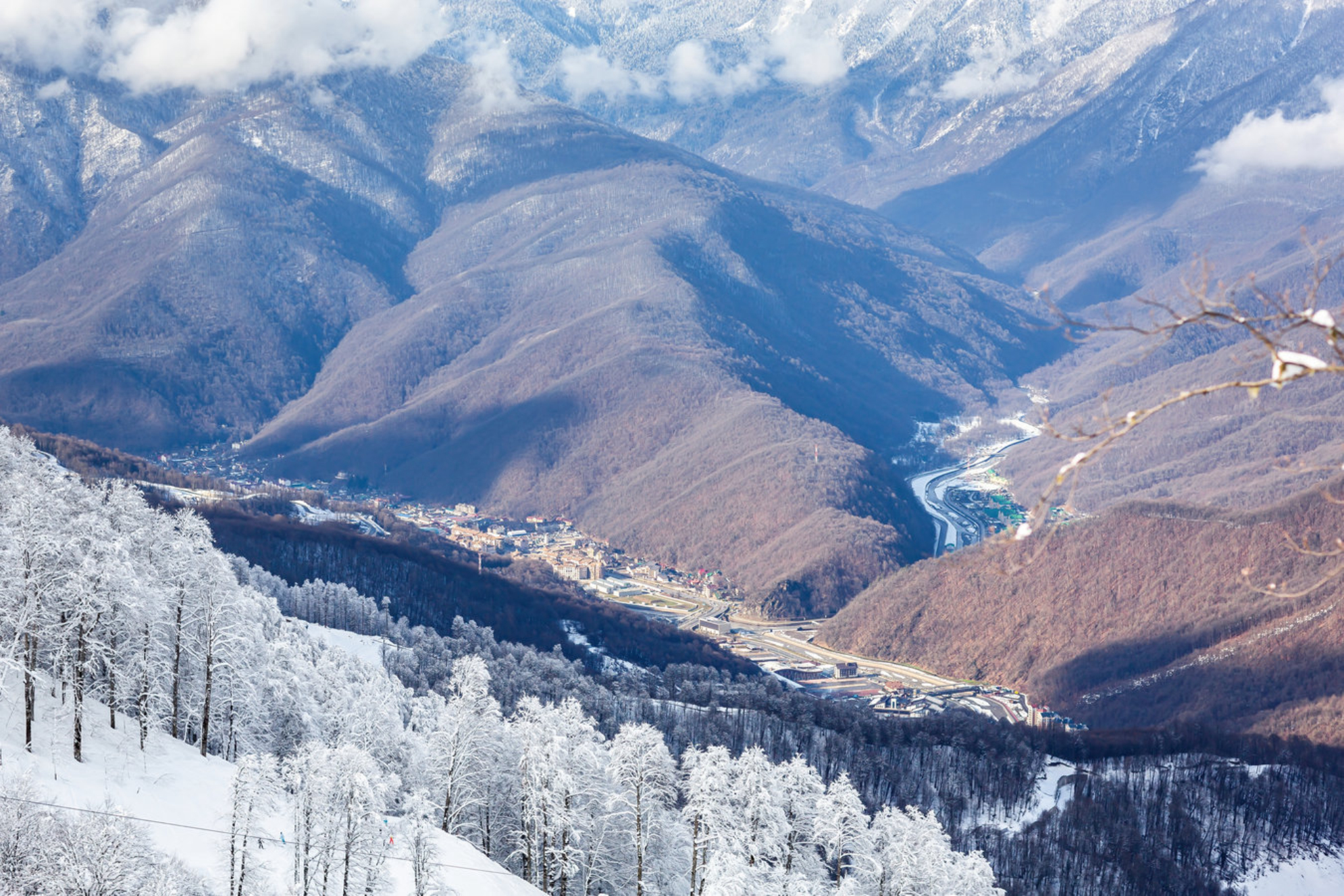Вид на долину реки Мзымта и деревню Красная Поляна с вершины гор. Источник: Shutterstock