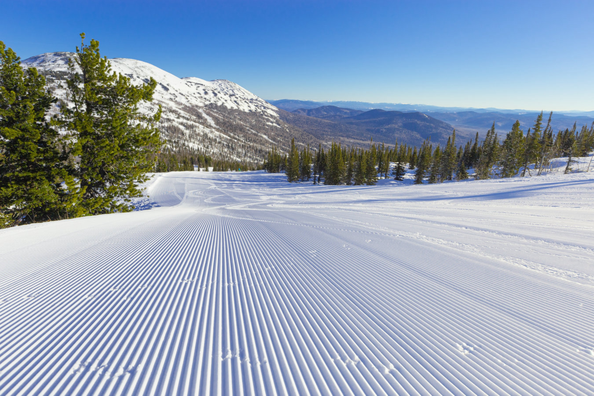 Снежный бархат и голубое небо на склоне горнолыжного курорта Шерегеш. Источник: Shutterstock