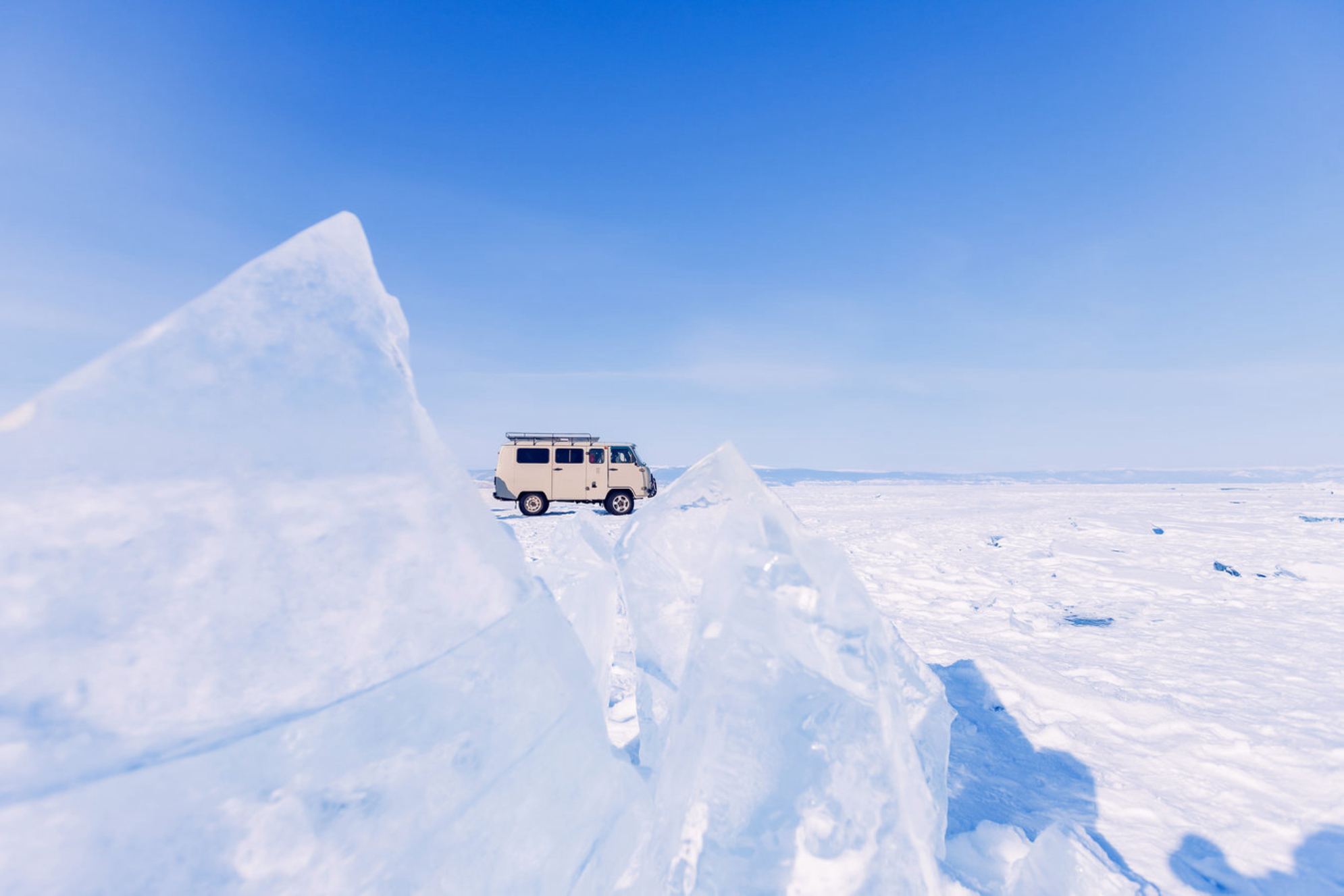 Туристический автобус на фоне замороженного льда озера Байкал. Источник: Shutterstock
