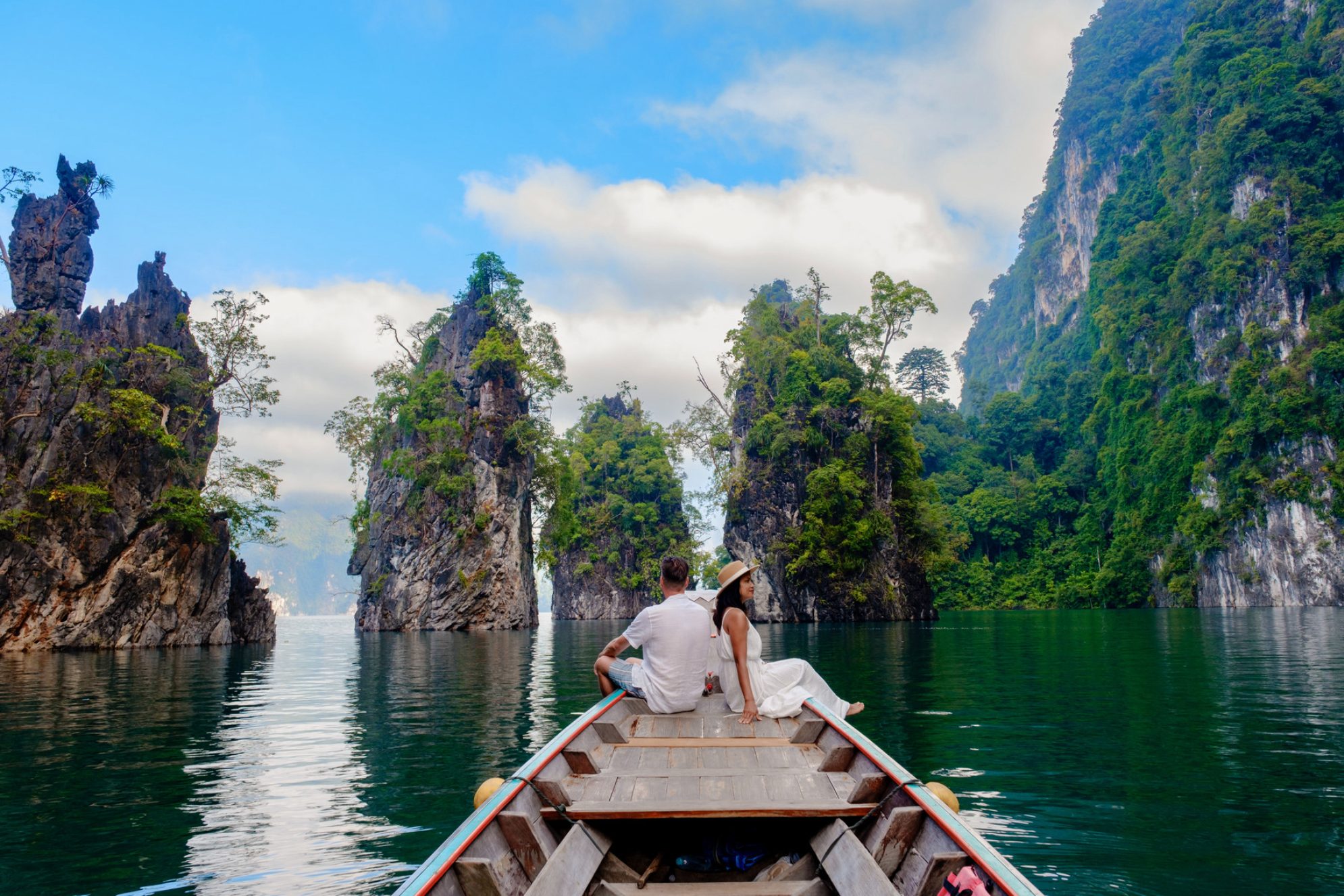 Пара отдыхает на традиционной лодке в спокойных водах озера Чжоу Лан в Као Соке, Таиланд. Источник: Shutterstock